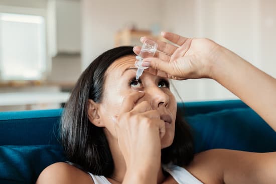 photo of woman using eye drops