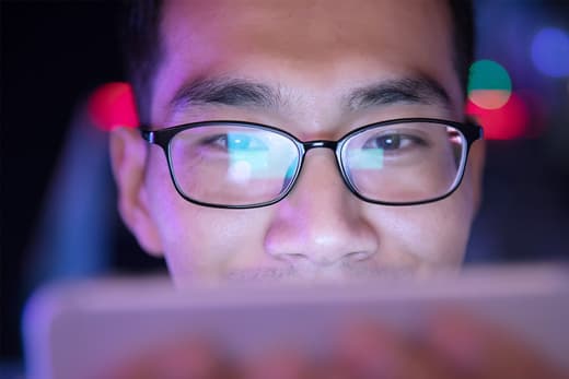 photo of man using smartphone at night