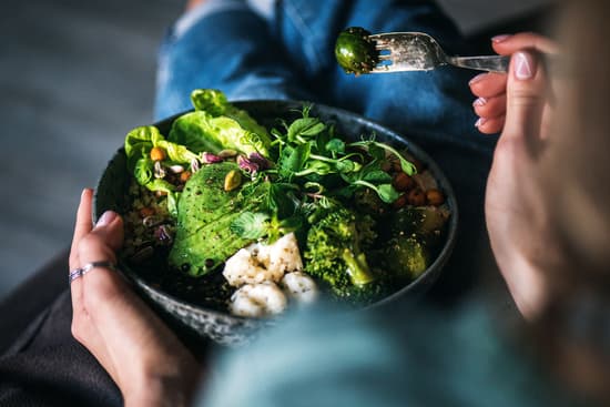 photo of woman eating vegetable bowl with hummus